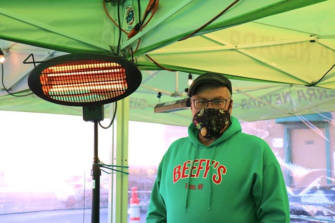 Roy Brennan, owner of Beefy’s in Reno, stands next to a heater inside the outdoor tent the restaurant installed this fall to bring in as much business as possible during the winter.