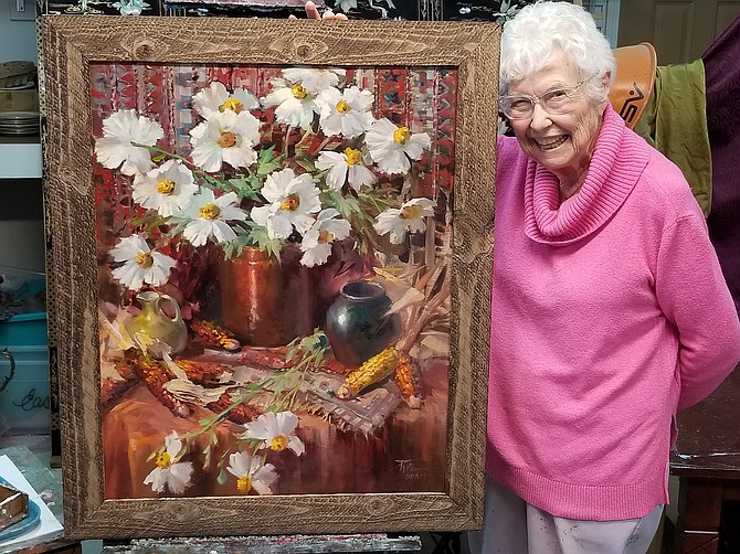 Artist Joyce Pike with the painting she's donating to the Sage Hens Scholarship Raffle.