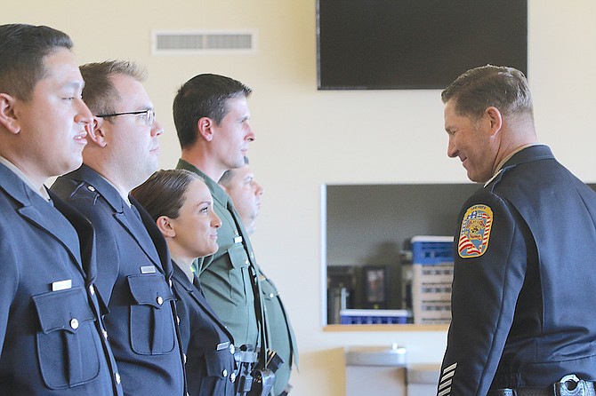 Sheriff Dan Coverley inspects field training officers during graduation at the Douglas County Community Center.