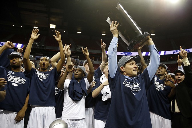 Nevada coach Eric Musselman hoists the trophy after Nevada defeated Colorado State 79-71 in an NCAA college basketball game for the Mountain West Conference tournament championship Saturday, March 11, 2017, in Las Vegas. (AP Photo/Isaac Brekken)