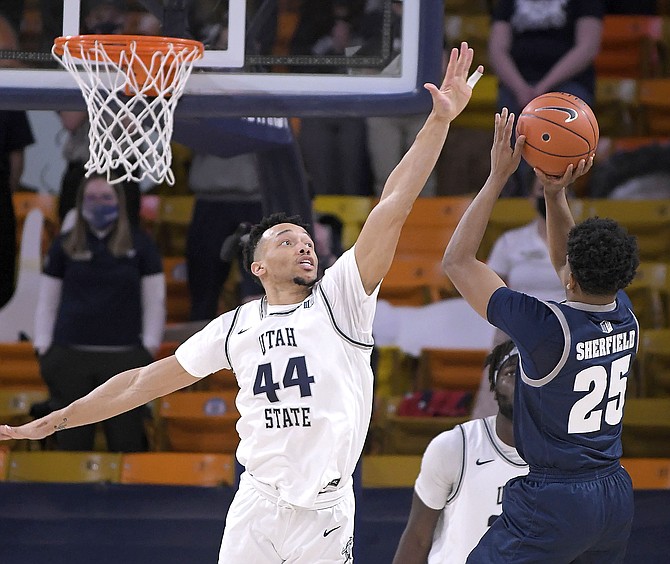 Nevada guard Grant Sherfield (25) shoots as Utah State guard Marco Anthony (44) defends during the second half of an NCAA college basketball game Friday, Feb. 26, 2021, in Logan, Utah. (Eli Lucero/The Herald Journal via AP, Pool)