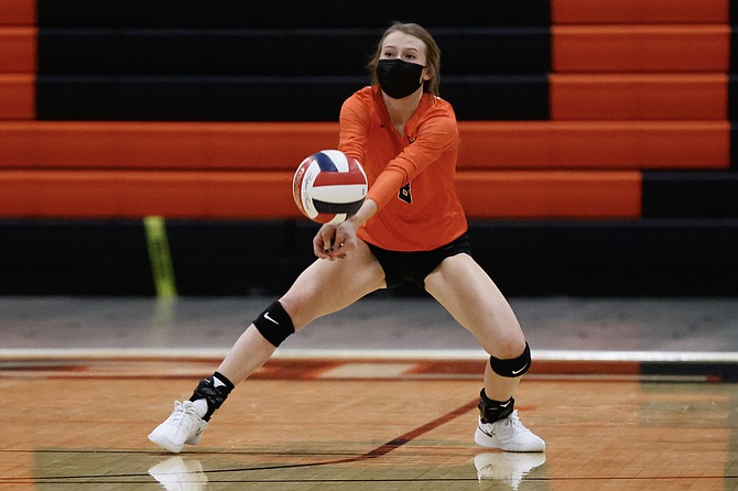 Douglas High's Caitlyn Stephens drops down to bump a ball against Reno High Thursday night. The Tigers fell in their home opener against the Huskies, but look to bounce back against Carson Tuesday