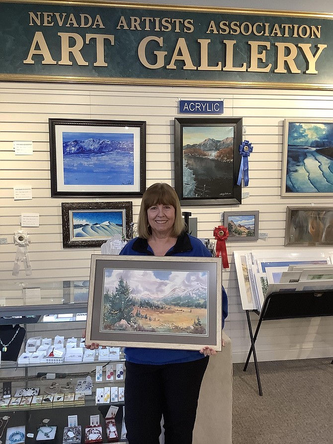Nevada Artists Association President Debbie Foster holds a framed print of former watercolor impressionist Lady Jill Mueller’s “Hope Valley” painting, which will be raffled off this summer in a fundraiser for Carson High School’s art department. Provided