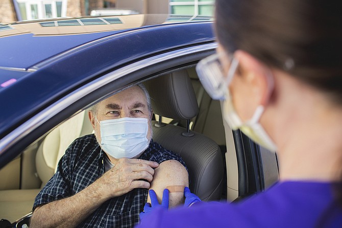 A Washoe County resident receives a dose of a COVID-19 vaccine earlier this year at the Renown Health drive-thru site at South Meadows.