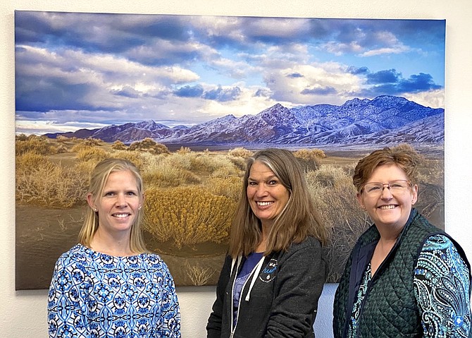 Casey Pomeroy, left, owner of Western Nevada Title, recently acquired new photos from local photographer Marie Nygren, center, which were printed by Suzie Slaybaugh, owner of Suzie's Picture Framing.