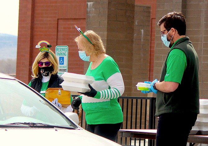 Douglas County Senior Center workers distribute corned beef and cabbage on St. Patrick's Day, a full year after the dining facility was closed by the coronavirus outbreak.
