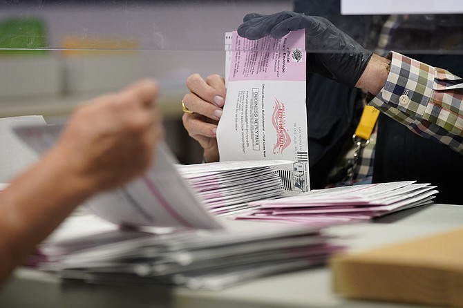 Clark County employees process mail-in ballots in Las Vegas on Oct. 31. (Photo: John Locher/AP, file)