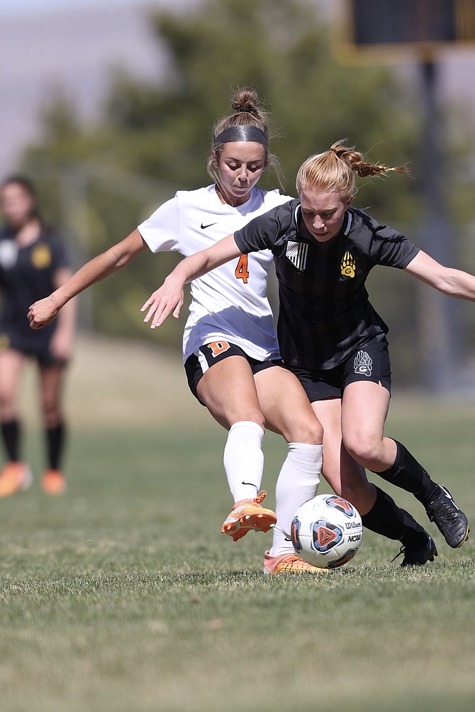 Kylee Lash (4) of Douglas High girls' soccer tries to get around a Galena defender Saturday.