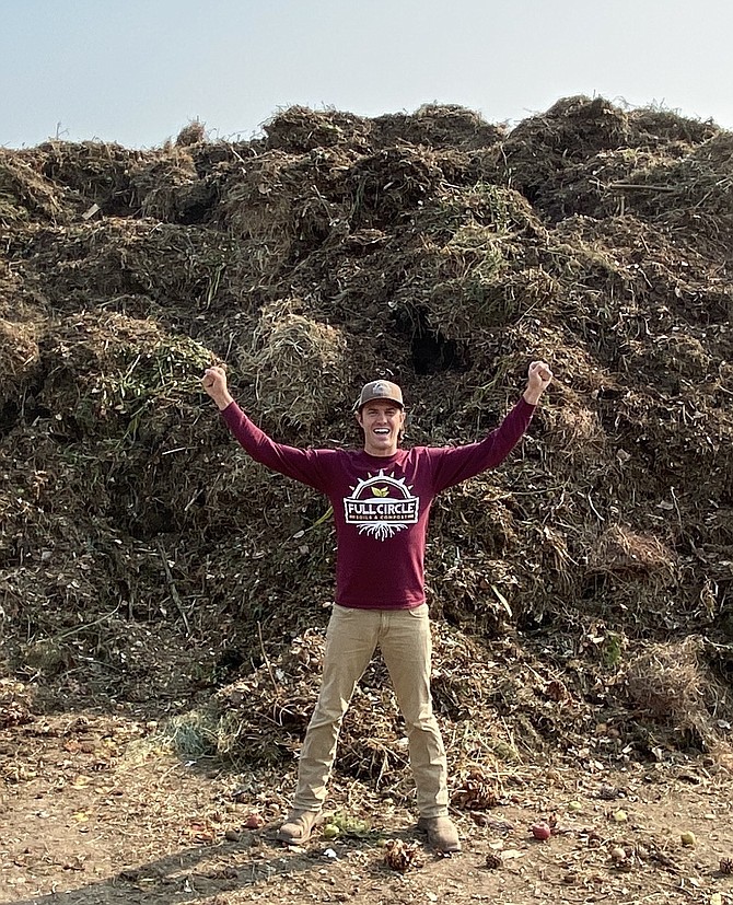 Cody Witt with a big pile of green waste recycled during 2020 into a range of soils and mulches. Full Circle Compost Photo