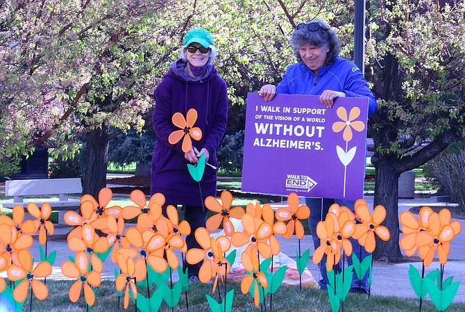 Northern Nevada Walk to End Alzheimer’s volunteers Barbara Stockton and Mary Torbik set up pinwheels and signs for the organization’s Promise Garden display in front of the Nevada Capitol on Thursday to raise awareness about the need for more support for patients, caregivers and anyone impacted by dementia. Stockton was diagnosed with mild cognitive impairment in 2017. (Jessica Garcia/Nevada Appeal )