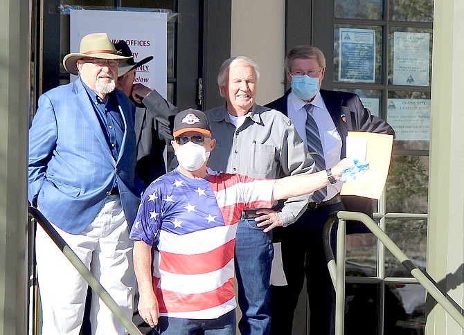 Douglas County commissioners stand in front of the Minden Inn on April 30, 2020, six weeks into the coronavirus outbreak, with a letter seeking to fully open businesses in the county. A year and a day later, it appears that will occur.