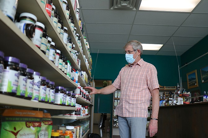 Tom Stewart, owner of Truckee Meadow Herbs, straightens the products on the shelves of his retail store on Wells Avenue in Reno.