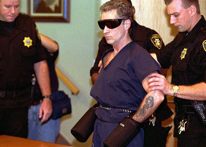 Death row inmate Patrick McKenna is escorted into district court under tight security to decide where his death penalty hearing will be held on Aug. 3, 1996, in Las Vegas. (AP Photo/Jack Dempsey)