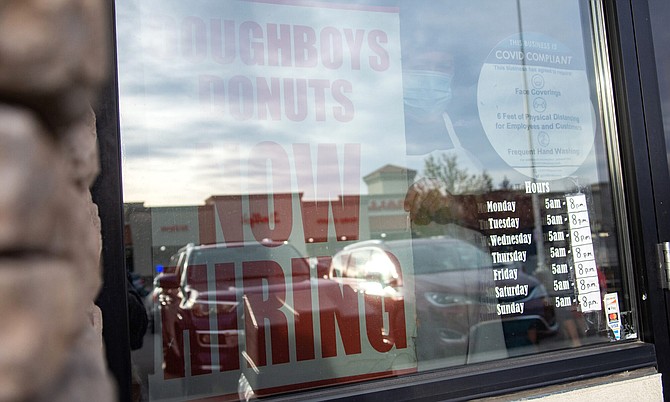 A sign advertising jobs hangs in the window of a DoughBoys Donuts location in Damonte Ranch in Reno on Friday, April 30, 2021.