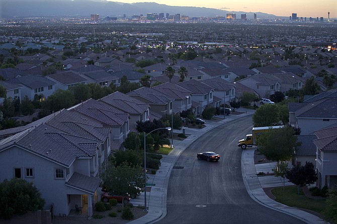 The Las Vegas skyline glows at dusk as a motorist pulls into the driveway of a home, in Henderson on May 29, 2013. (Photo: Julie Jacobson/AP, file)