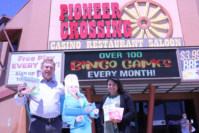 Dayton’s Pioneer Crossing Casino General Manager Dave Murray and United Way of Northern Nevada and the Sierra Director of Marketing and Engagement Ashley Cabrera stand with a cutout of Dolly Parton and several books Friday. The casino has donated to United Way to bring free books to Carson City, Douglas County, Lyon County and Churchill County. (Photo: Jessica Garcia/Nevada Appeal)