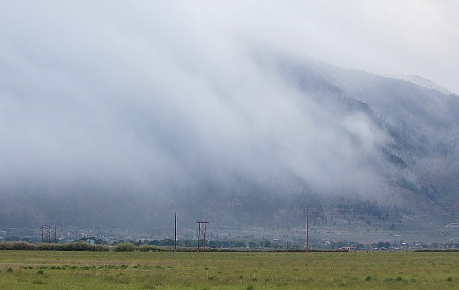 Clouds pour over the Carson Range on Friday night with a new burst of precipitation.