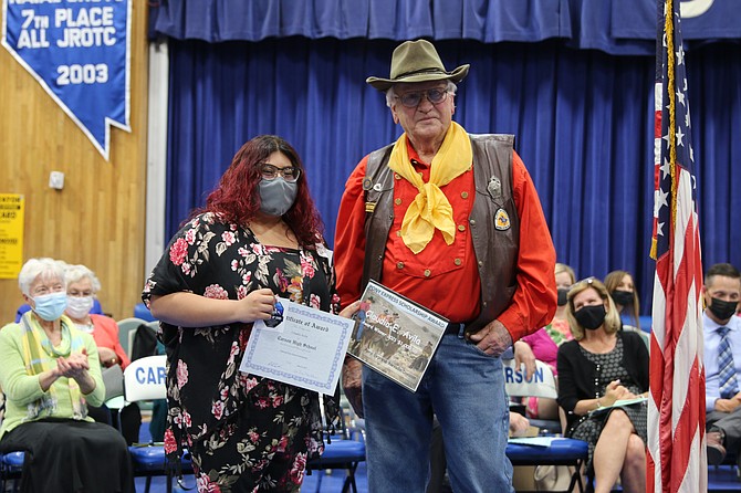 Claudia Avila receives a $1,000 scholarship at Tuesday’s Carson High School Salute to Scholars event from Ron Bell of the Pony Express Nevada Division.