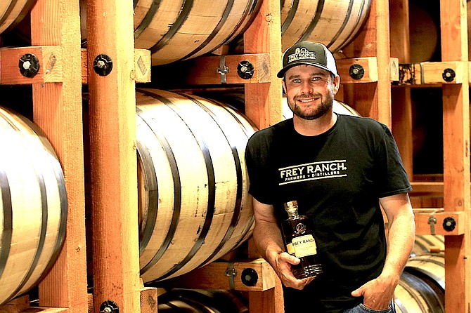 Colby Frey shows a bottle of the Frey Ranch bourbon and barrels of aging whiskey at his distillery south of Fallon. The San Francisco World Spirits Competition recently awarded Frey Ranch Distillery eight medals including two double golds.
