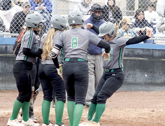 Rachel Mori’s teammates greet her at home plate after she hit a home run against Fernley.
