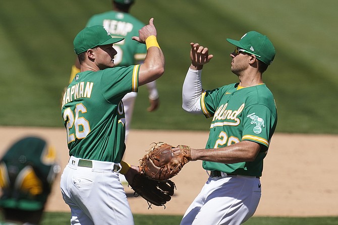 Oakland Athletics' Matt Chapman, left, celebrates with Matt Olson after the Athletics defeated the Seattle Mariners in a baseball game in Oakland, Calif., Wednesday, May 26, 2021. (AP Photo/Jeff Chiu)