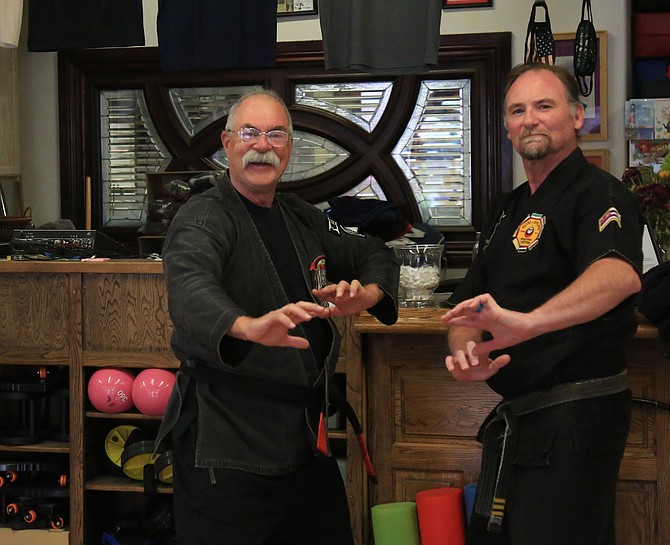 Kenpo karate instructor Jhan Yaple and fellow instructor Sean Morey pose for a photo inside of Yaples’s Adult Kenpo Karate business.