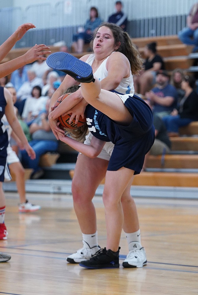 Oasis Academy’s Gabby Grimes fights for possession against Coral Academy in Friday night’s game.