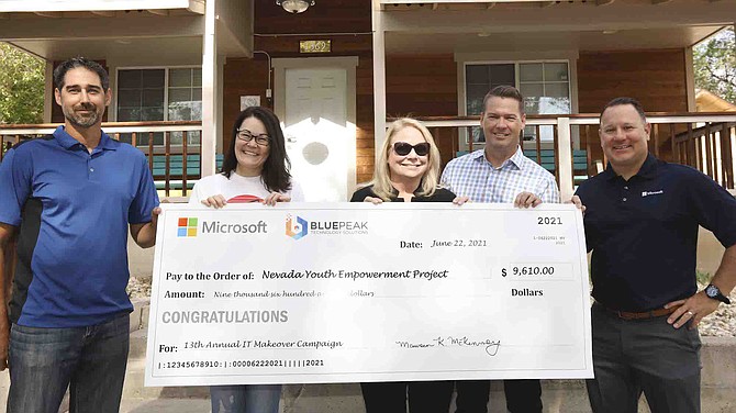 Monica DuPea, Executive Director of the Nevada Youth Empowerment Project in Reno, accepts a $9,610 donation check from Microsoft Reno and BluePeak Technology Solutions representatives on June 22, 2021.