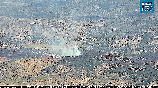 A puff of smoke rises over the East Fork Fire burning southeast of Gardnerville on Tuesday afternoon.