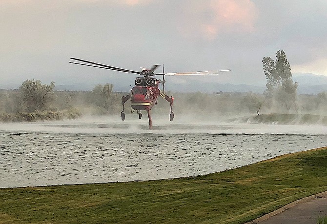 A helicopter dips into one of the Sunridge Golf Course ponds while fighting the Prison Hill fire above Carson City on Friday in this shot by former Record-Courier photographer Shannon Litz. A fire weather watch has been issued for the Sierra Front on Thursday.