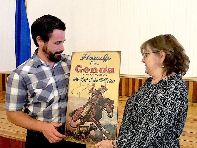 Former Genoa Town Manager JT Chevallier receives a poster from Town Board Member Linda Birdwell on Wednesday evening.