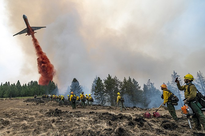 Wildland firefighters watch and take video with their cellphones as a plane drops fire retardant on Harlow Ridge above the Lick Creek Fire, southwest of Asotin, Wash., on Monday. The fire, which started last Wednesday, has burned over 50,000 acres of land between Asotin County and Garfield County in southeast Washington state. (Photo: Pete Caster/Lewiston Tribune via AP)