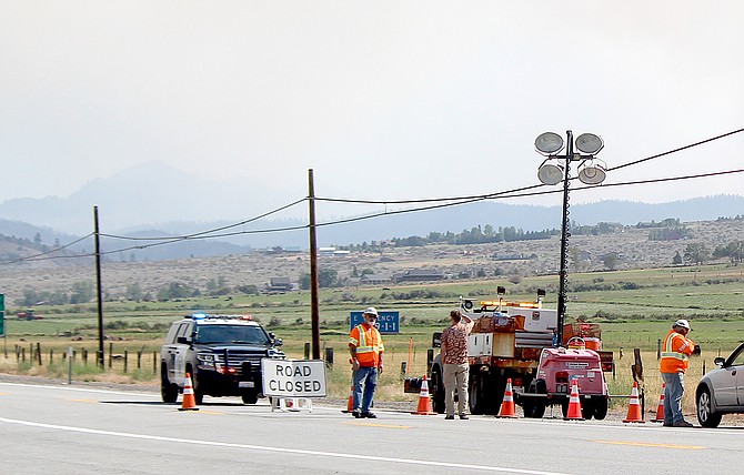 Cal Trans workers talk to a motorist at Highway 88 and the state line on Tuesday afternoon. Highway 88 was closed as the Tamarack Fire continues to expand.