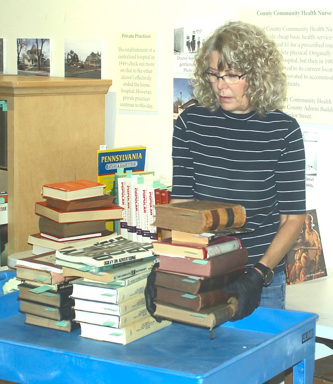 Museum Director Teri Hedgpeth sorts books for a big sale for the next two weeks.