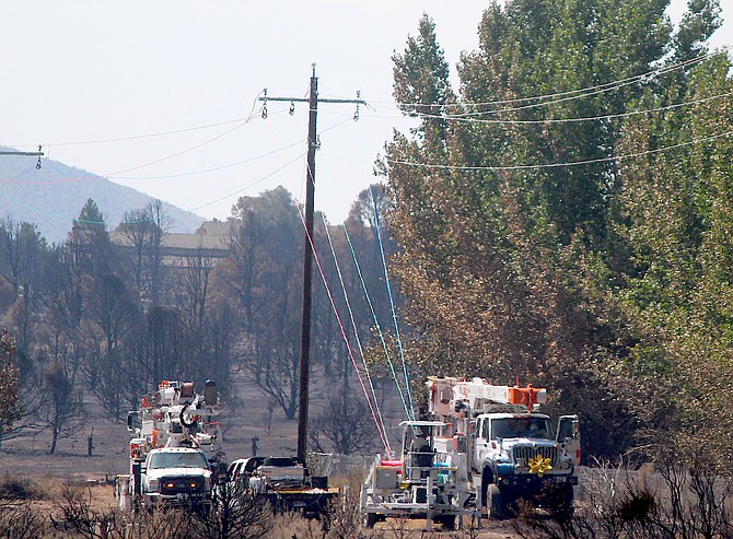 NV Energy linemen string wire just north of Holbrook Junction after a section of power poles and line was destroyed in the Tamarack Fire.