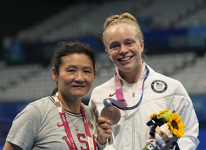 Krysta Palmer and her coach Jian Li You pose for a photo after winning the bronze medal in women's diving 3m springboard final at the Tokyo Aquatics Centre on Aug. 1, 2021, in Tokyo. (AP Photo/Dmitri Lovetsky)