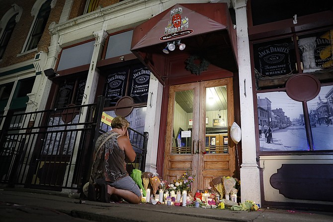 Mourners visit a makeshift memorial outside Ned Peppers bar following a vigil at the scene of the mass shooting in Dayton, Ohio, on Aug. 4, 2019. (AP Photo/John Minchillo, File)