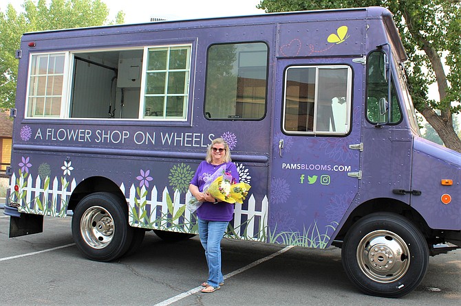Pam Karg, owner of Pam’s Blooms, stands beside “Petunia,” her Flower Shop on Wheels. (Photo: Ronni Hannaman)