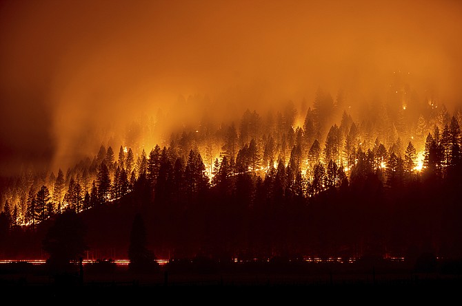 The Dixie Fire burns down a hillside towards Diamond Mountain Road near Taylorsville in Plumas County, Calif., on Friday. (AP Photo/Noah Berger)