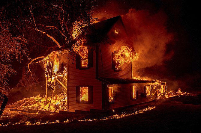 A home burns on Jeters Road as the Dixie Fire jumps U.S. Highway 395 south of Janesville, Calif., on Monday, Aug. 16, 2021. Critical fire weather throughout the region threatens to spread multiple wildfires burning in Northern California. (AP Photo/Ethan Swope)