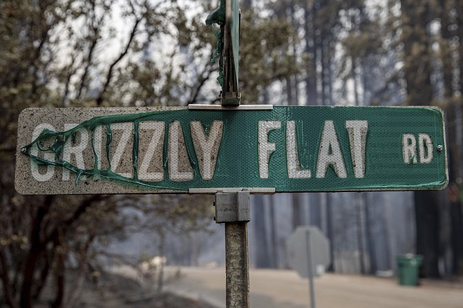 A partially melted street sign stands after the Caldor Fire burned through Grizzly Flats, Calif., on Tuesday, Aug. 17, 2021. (AP Photo/Ethan Swope)