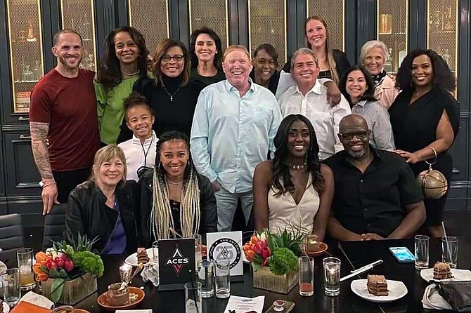 This photo provided by Sylvia Crawley Spann, shows former WNBA player Sylvia Crawley Spann and her husband Brian, seated bottom right, celebrating their wedding with Las Vegas Aces WNBA basketball team owner Mark Davis, standing at center, and other former members of the franchise and their guests at a restaurant in Las Vegas on May 29.