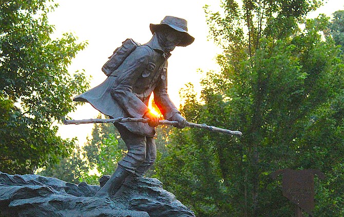 A red sun rises over Genoa this morning shining on the statue of Snowshoe Thompson.