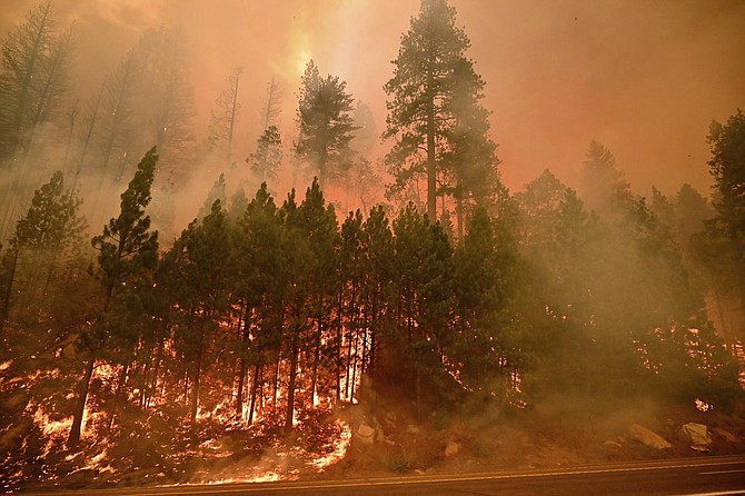 The Caldor Fire burns on both sides of Highway 50 about 10 miles east of Kyburz, Calif., on Thursday, Aug. 26, 2021. (Sara Nevis/The Sacramento Bee via AP)
