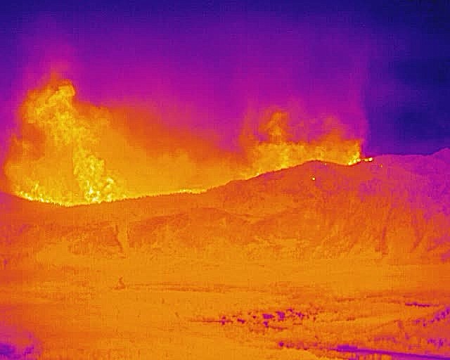 The ALERTWildfire thermal camera atop the Heavenly Mountain Resort at South Lake Tahoe, California  allows the fire to be monitored through the heavy smoke and provides early identification of spot fires as seen  The bright areas of the photo shows the height of the heat signature, not necessarily the height of the flames. The photo shows the view on Sunday evening, Aug. 29 looking to the west.