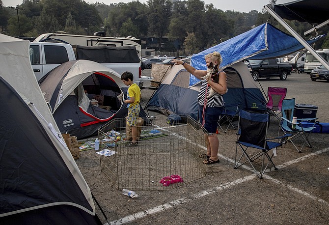 Julie Price points while talking to another evacuee at the Green Valley Community Church evacuation shelter on Thursday, Aug. 19, 2021, in Placerville, Calif., after fleeing the Caldor Fire. (AP Photo/Ethan Swope)