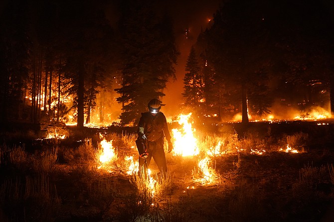 A firefighter lights a backfire to stop the Caldor Fire from spreading near South Lake Tahoe, Calif., on Wednesday, Sept. 1, 2021. (AP Photo/Jae C. Hong)