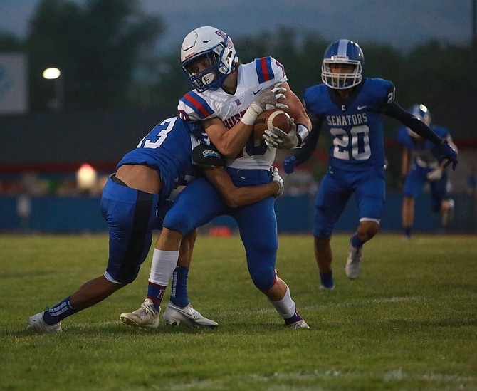 Isaac Avina (33) pushes a Reno wide receiver backward for a tackle during the Senators' first full football game against the Huskies Friday night.