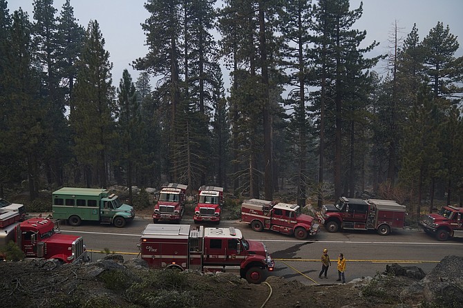 Fire trucks are parked along Highway 89 as fire crews build a fire line to keep the Caldor Fire from spreading in South Lake Tahoe, Calif., on Friday, Sept. 3, 2021. (AP Photo/Jae C. Hong)