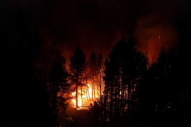 FILE - In this Sept. 3, 2021, file photo, the Caldor Fire consumes trees in Eldorado National Forest, Calif.